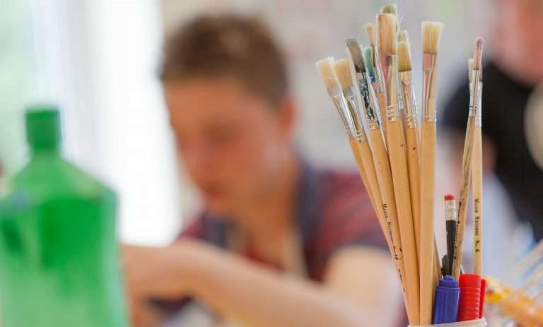Paint brushes with young boy in background