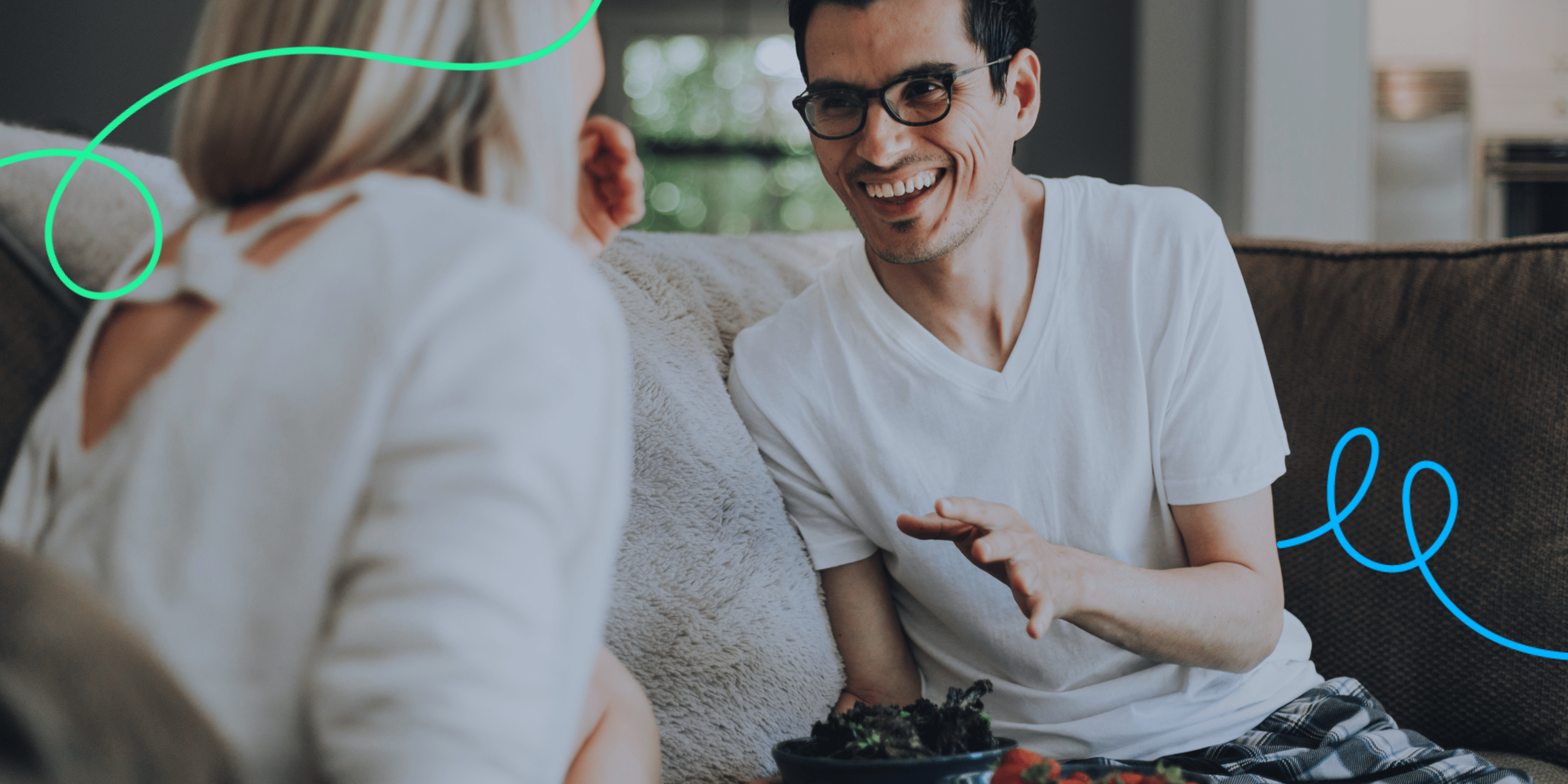 Adult and support worker sitting on the sofa chatting and smiling