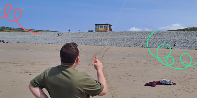 Photo of adult flying kite on the beach in the sun