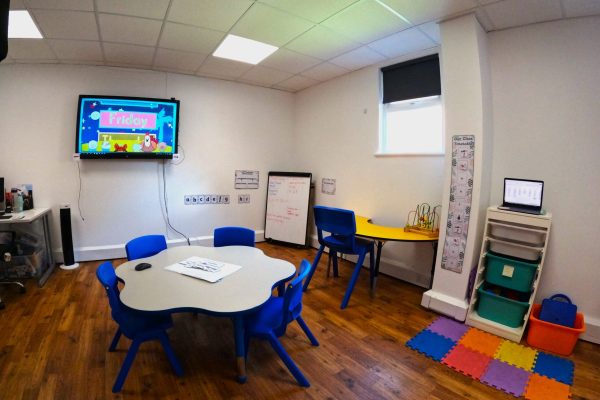 Small classroom space with a TV screen for learning and a whiteboard.